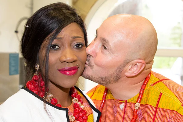 wedding couple in african national dress traditional costume and caucasian groom