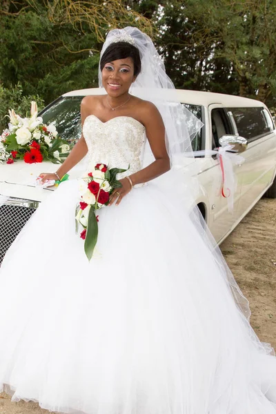 African-American black woman in white wedding dress with limo car