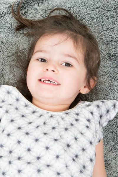 快乐的小可爱的女孩有乐趣在家里毯子 — 图库照片