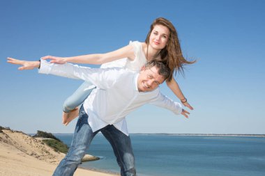 Oynamak ve eğlenmek içinde güneşli tropikal hedef seyahat tatil için yakışıklı beyaz erkek erkeğe piggybacking neşeli güzel kız