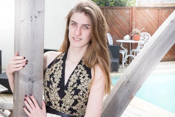 pretty young blonde woman smiling by the pool at home