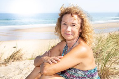 gülümseyen kıdemli sarışın kadın kenar dune Beach yaz aylarında emekli