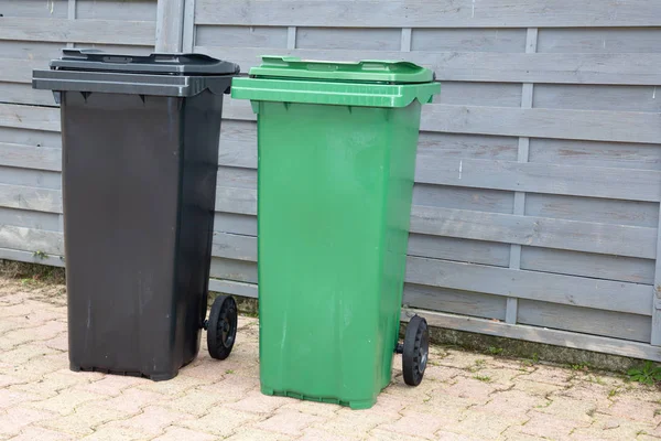 black and green plastic garbage bin in street for recycling concepts and designs