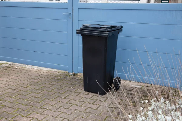 Black trash container garbage bin in street