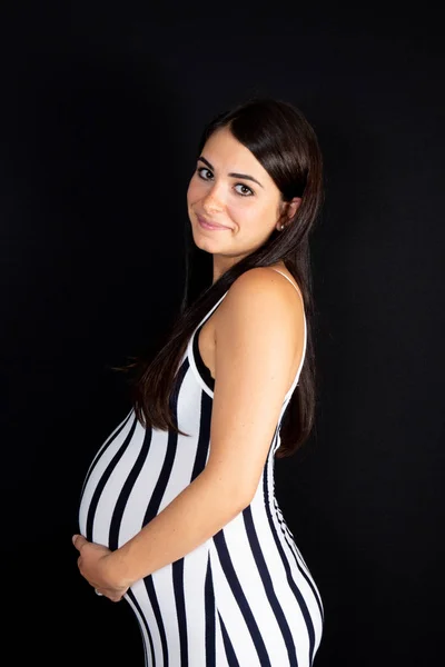 年轻美丽的孕妇站立在家在黑色背景 — 图库照片