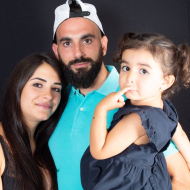 Genç aile yaşam tarzının üç anne baba ve çocuk kızı siyah arka plan üzerine