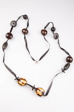 Beyaz arka plan üzerinde şerit ile kahverengi boncuk kolye