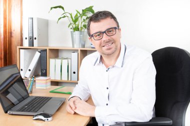 yakışıklı işadamı ile iş yerinde bilgisayar laptop ofiste oturmak