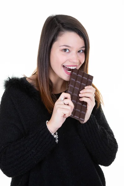 若い女性の肖像画は 白い背景の上のチョコレート バーを食べる — ストック写真