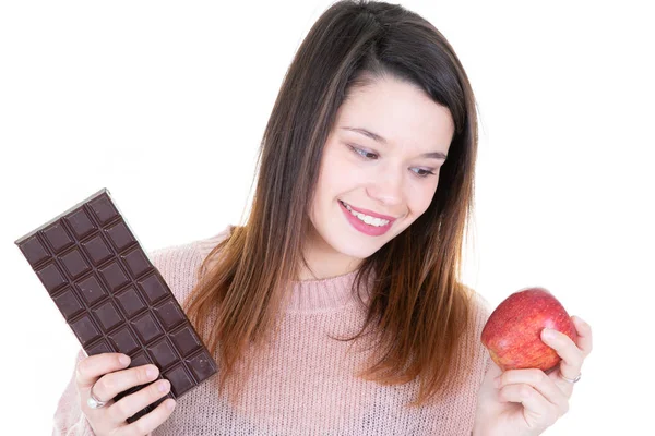 幸せな女の白い背景の上の暗いチョコレートと赤いリンゴ果実の間の選択 — ストック写真