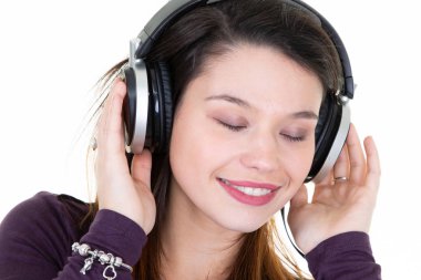 Genç kız öğrencilerin oturma portre beyaz arka plan üzerinde izole müzik dinlemek