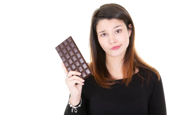 チョコレートの誘惑でそれを見るの大きなバーとかわいい若い女性 — ストック写真