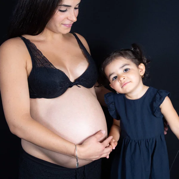 Boldog Gyerek Lány Terhes Anya Hasát Átölelve Fekete Háttér — Stock Fotó