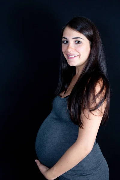 Těhotná Žena Hladí Její Břicho Pod Černým Pozadím — Stock fotografie