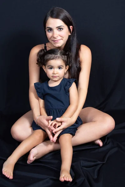 Mutter Sitzt Mit Ihrer Tochter Unter Schwarzem Boden Wand Studio — Stockfoto