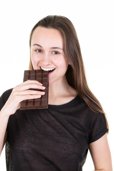 チョコレート バーを噛んで満足しているかわいい女の子の肖像画 — ストック写真