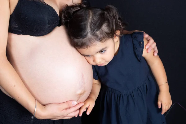 愉快的姐妹拥抱听怀孕的母亲肚子 — 图库照片