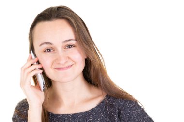 Beyaz arka plan üzerinde rahat güzel genç kadın holding smartphone gülümseyen portresi