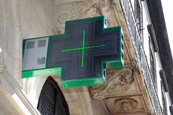 cross green pharmacy sign outside a pharmacy store in France