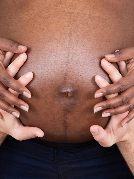亲密的爱怀孕夫妇的手在腹部白色和黑色混合种族 — 图库照片