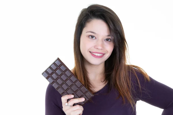押しながらココア白背景の壁の近くのバー チョコレートを食べるチョコレートの笑顔のかわいい女の子と女性 — ストック写真