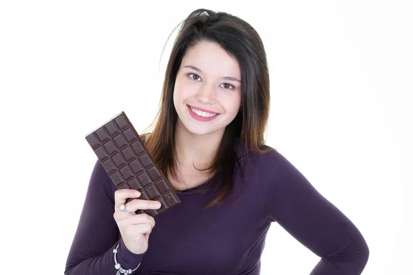 白い壁の背景に分離の手にチョコレート バーのセーターで若い女性を笑ってください — ストック写真