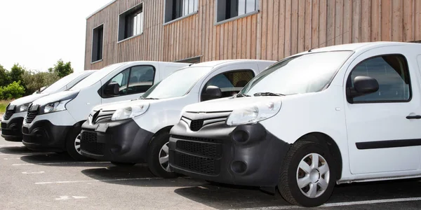 Row white delivery service van small trucks park front of factor — Stock Photo, Image