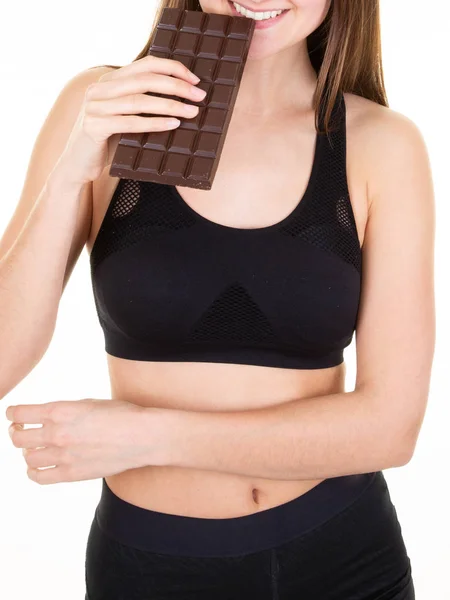 スリムな女性スポーティーな食べるチョコレートバー孤立した白の背景 — ストック写真
