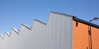 mavi gökyüzünde endüstriyel bina tipi gri ve turuncu fabrika