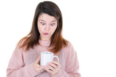 Genç esmer kadın elinde çay fincanı kupasıyla beyaz arka planda kahve tutuyor.