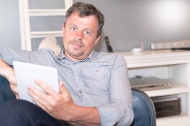 handsome man surfing on tablet in home living room