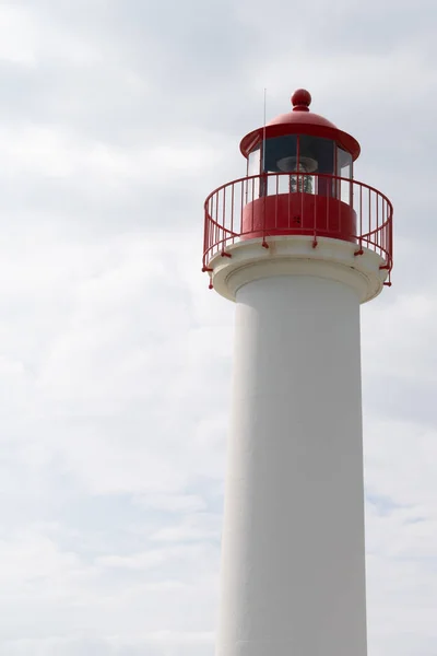 red and white lighthouse for boat in cloud sky vertical