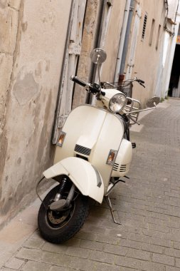 İtalyan sokakları şehir şehir ve boş sokakta duvar tarafından park edilmiş popüler bir tek ulaşım scooter