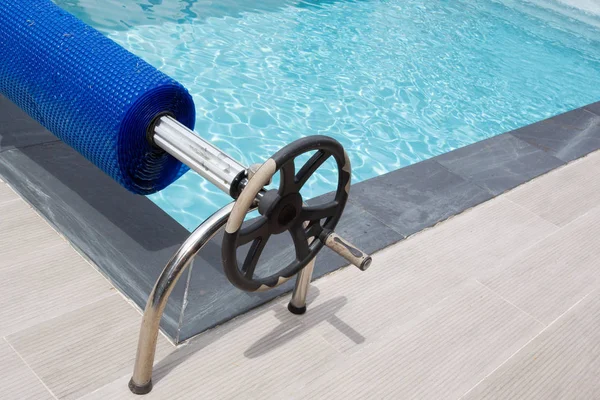 swimming pool with blue bubble cover winder and steering wheel