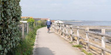 man riding cycle on bike paths of ile de Re at the edge of the Atlantic Ocean france in web banner template web clipart