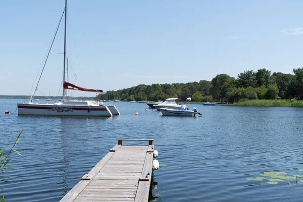 wood pontoon in lake in Lacanau city in France with sail boat in summer water