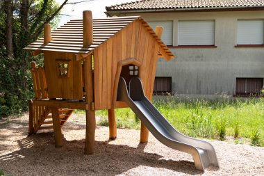 playground in urban park forest with wooden hut and slide clipart