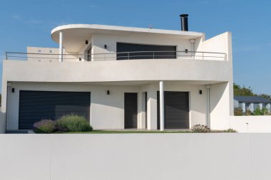 mavi gökyüzünde gri duvarlı modern beyaz ev lüks villa