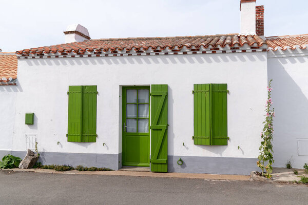 Фасад Белого дома с зелеными ставнями жалюзи и дверь в Noirmoutier острова Франция
