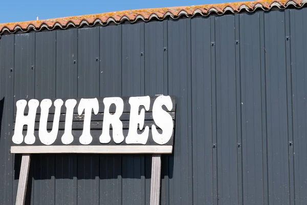 Closeup of sign in farm restaurant Oyster Tasting means Huitres in French on Arcachon Cap ferret fisherman wood hut