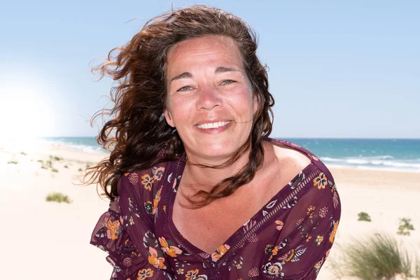 Beautiful woman on wind summer beach smiling