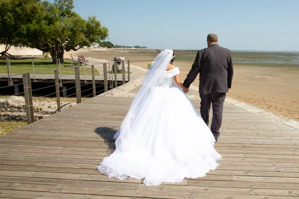 夏の日に砂浜海岸の近くで楽しんでいるスタイリッシュな結婚式のカップル — ストック写真