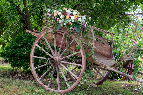 Picturesque old wooden ancient cart decorated with flower for a wedding