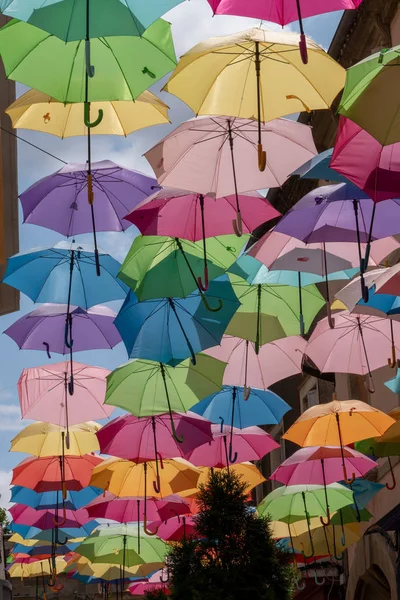 Decoración Calle Con Coloridos Paraguas Abiertos Colgando Entre Edificios Sobre —  Fotos de Stock