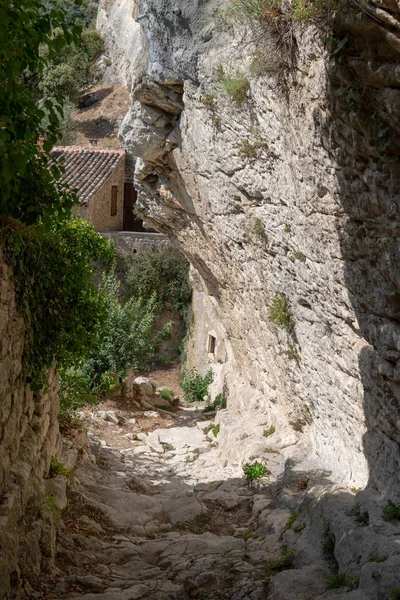 alley street cut into the rock of the mountain with houses in hilltop village Oppede Le Vieux in Provence France