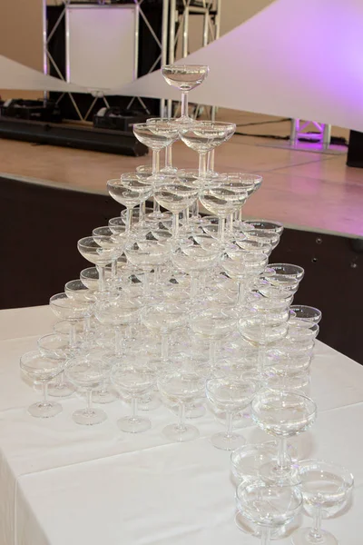 champagne glasses standing in pyramid tower at the party