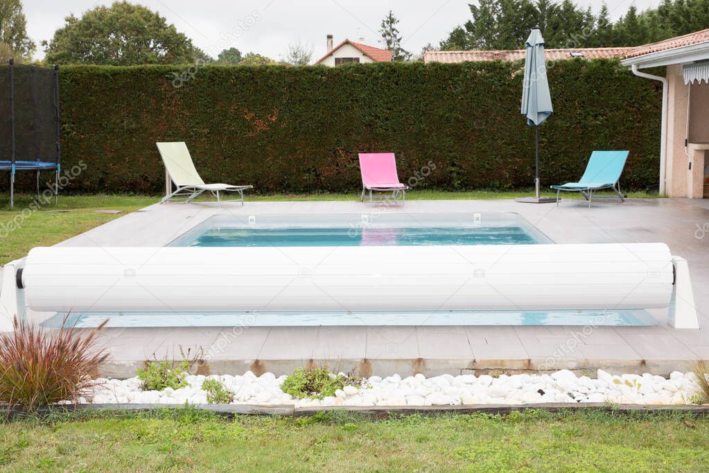 rigid cover rolls over an outdoor swimming pool