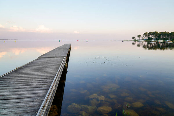 sunrise on wooden pontoon in sunset Lake lacanau in Gironde france