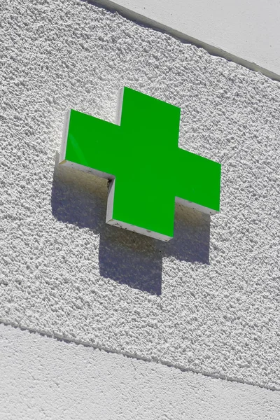 green cross logo of Pharmacy sign in street
