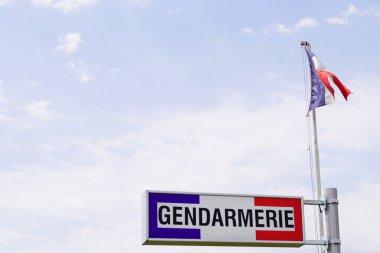 Gendarmerie french military police sign and french flag in cloudy sky clipart